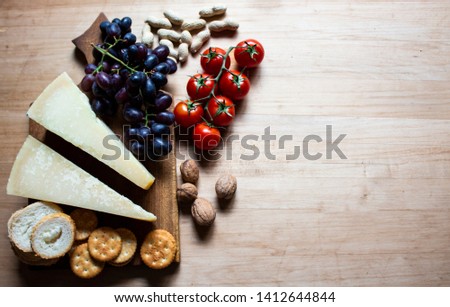 Cheese on a wooden board. Cheese, grapes and cracker. copy space
