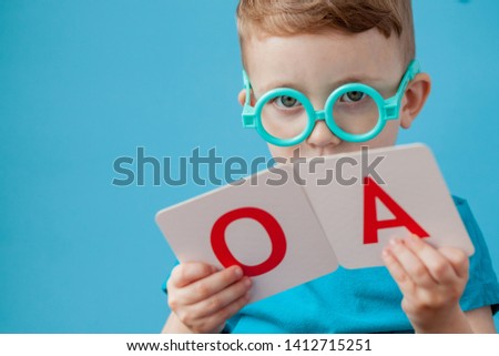 Cute little boy with letter on background. Child learn letters. Alphabet.