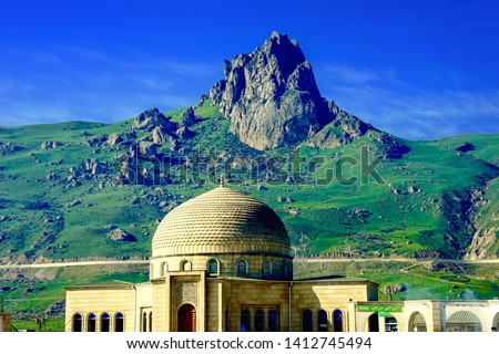 Azerbaijan, on the way to the village of Xinaliq, high up in the northern Caucasus mountains. The Beshbarmag Daghi (Five-finger mountain ) and nearby mosque. Royalty-Free Stock Photo #1412745494