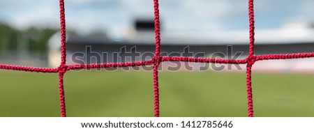 Football goals at stadium. Soccer field background. White and red nets color.