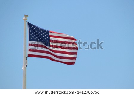 American flag waving on a clear blue sunny day. 