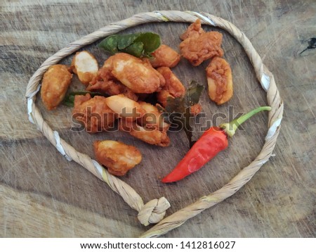 peeled peanuts using flour dressing are given chili as a spicy flavor enhancer and fried in orange leaves as an aroma enhancer