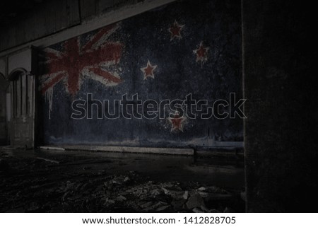 painted flag of new zealand on the dirty old wall in an abandoned ruined house. concept