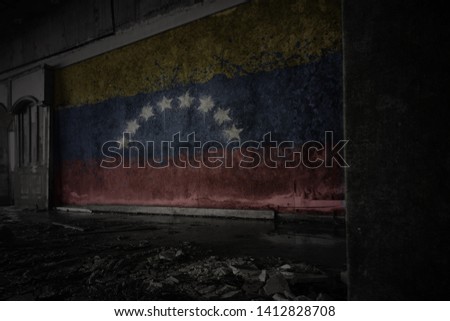 painted flag of venezuela on the dirty old wall in an abandoned ruined house. concept