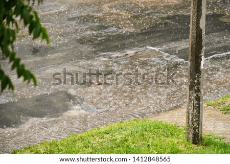 Asphalt road with holes and sidewalk during heavy rain on a summer day. Theme safety on the road.