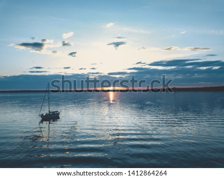 Sailboat Anchored on the Water during Sunset