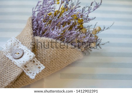 Elegant beautiful vintage bouquet of dried flowers on musical paper. Horizontal close-up. Can be used as background