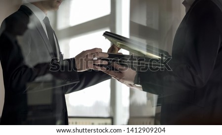 Businessman checking dollars in briefcase, kickback in illegal cooperation Royalty-Free Stock Photo #1412909204