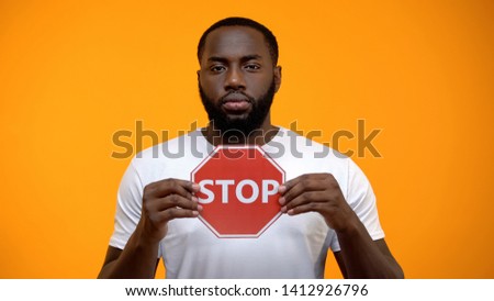 Afro-American man showing stop sign, male against racial discrimination, closeup