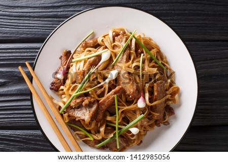 Beef Chow Fun Noodles (Pan-Fried Ho Fun) Cantonese dish closeup on the plate on the wooden table. horizontal top view from above
 Royalty-Free Stock Photo #1412985056