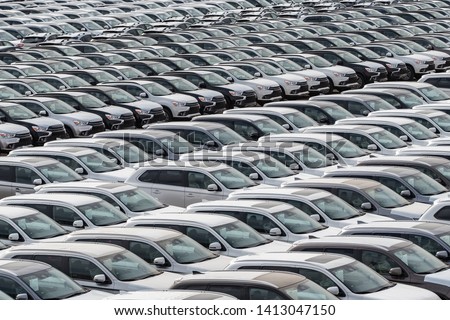 Row of new cars for sale in port. New automobiles background