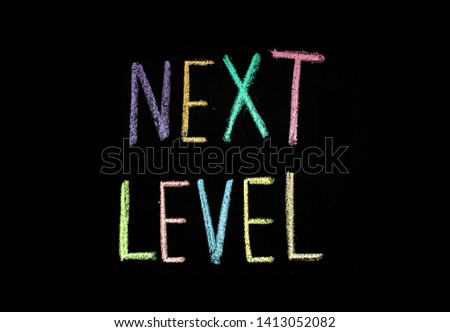 colored text "next level" written  on chalkboard