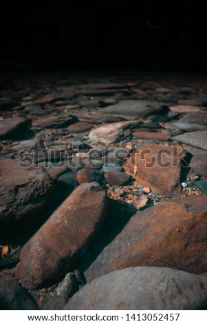 Rocks and pebbles lay on a submerged creek bed.