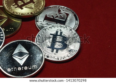 a collection of cryptocurrency coins on a velvet red background