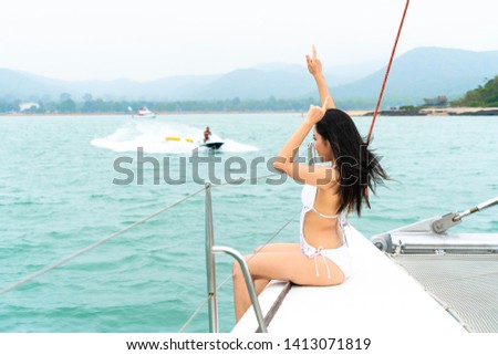 bikini  happy girl sit on boat yacht with in front of sea and sky. With jet ski boat drive on background