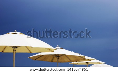 Opened umbrellas by deep blue sky