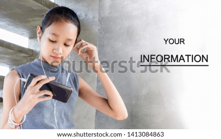 Portrait of Pretty Asian young girl using headphone for listening to music by smartphone happily. Children addicted to social media games concept.