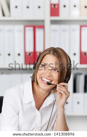 Laughing businesswoman talking on headset in the office