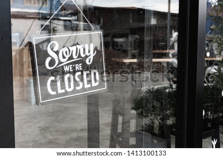 Sorry we're closed sign. grunge image hanging on a dirty glass door. Royalty-Free Stock Photo #1413100133