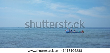 Picture of a fishing boat sailing in blue sea, under clouded blue sky.