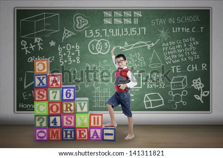 Asian student boy stepping on crossword in class