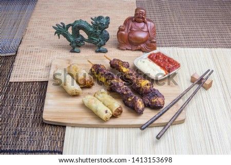 Asian food: nems with chicken skewers, served with asian decoration.
