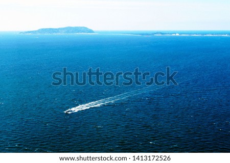Boat yacht in the sea rides at high speed. In the background is an island. Fukuoka, Japan.                            