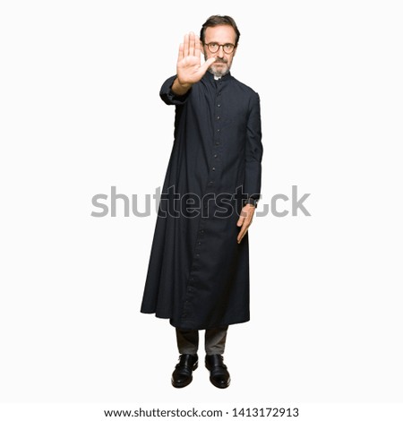 Middle age priest man wearing catholic robe doing stop sing with palm of the hand. Warning expression with negative and serious gesture on the face.