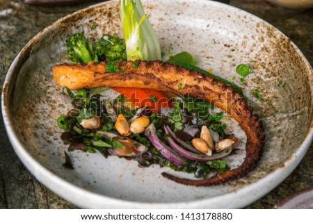 Fried octopus, served in a ceramic plate on a marble table.
