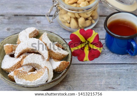 Putri Salju Kacang Mede or crescent-shaped cookies with cashew coated with powdered sugar. Popular Indonesian dessert to celebrate Eid al Fitr or Idul Fitri. Served with tea