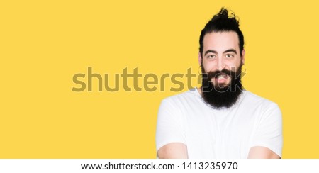 Young hipster man with long hair and beard wearing casual white t-shirt Smiling with hands palms together receiving or giving gesture. Hold and protection