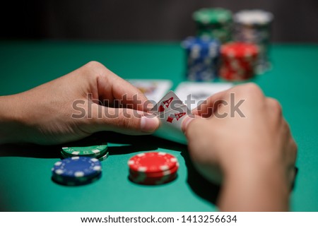 Poker Aces pair .green poker table with top pair. casino gambling. playing cards close-up. poker player watching his hand Royalty-Free Stock Photo #1413256634