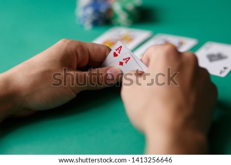 Poker Aces pair .green poker table with top pair. casino gambling. playing cards close-up. poker player watching his hand