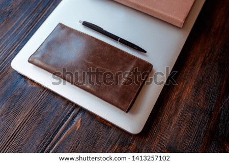 work space of a businessman. view from above . coffee black note and laptop on the desktop with black note. laptop on wooden background