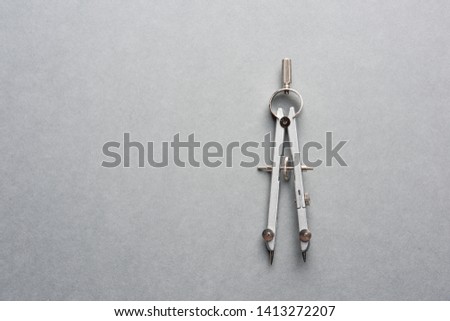 A metal compass on grey background