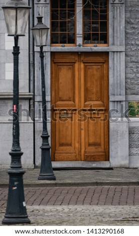 Image of isolated doors in old building. Street lamps along the street.