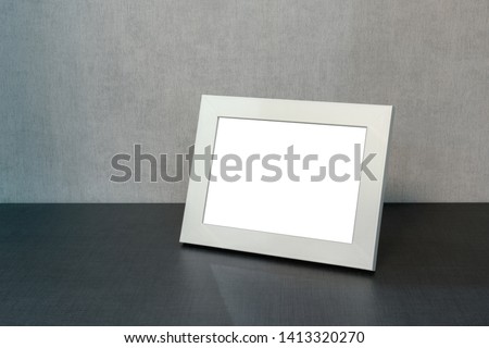 white photo frame horizontally stands on the shelf in the living room, minimalism in the interior of the house, mock-up