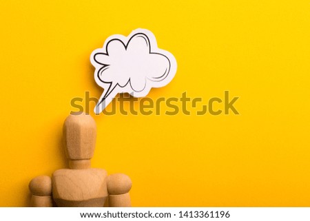 Thinking concept with blank speech bubble and wooden man on yellow background with copy space.