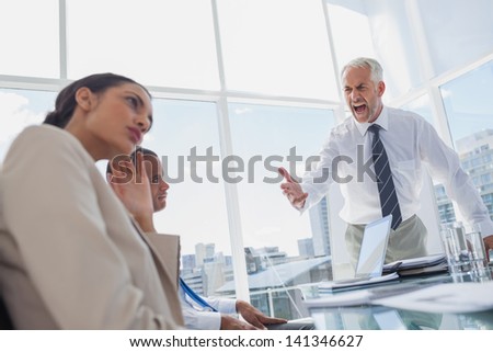 Furious boss yelling at colleagues during a meeting Royalty-Free Stock Photo #141346627