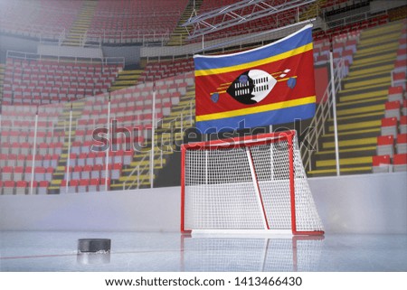 Flag of Swaziland in hockey arena with puck and net