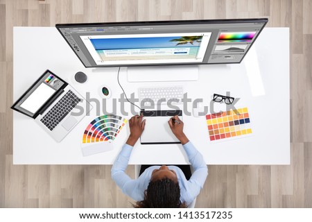 Young Female Designer Editing Photos On Computer In Office