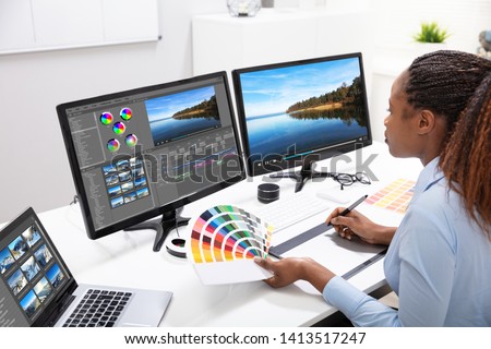 Young Female Editor Editing Video On Computer In Office