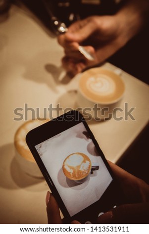 Barista conducts a trainee masterclass, teaches work. Trainee takes pictures