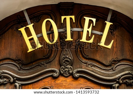 Beautiful HOTEL  sign - metallic plate next to entrance wooden door 