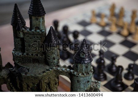 Chess board game concept of business ideas and competition. Chess figures and old medieval castle on a chessboard. Outdoor sunset background. Selective focus