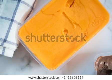 Top view box of passion fruit flavor ice cream in box on marble background