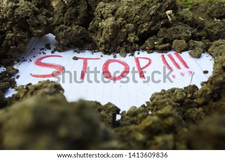 the words "stop" on paper buried on the ground
