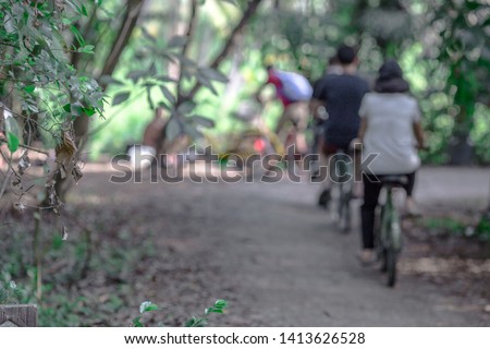 Blurred background of people who are cycling fast, exercising in the park in the morning - evening, the atmosphere is surrounded by nature.