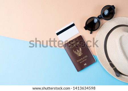 Top view travel concept with passport, credit card, sunglasses and hat on abstract beach background