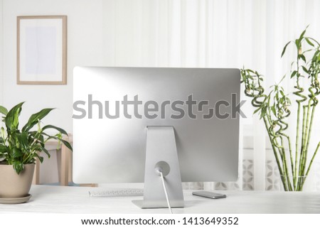Office interior with houseplants and computer monitor on table
